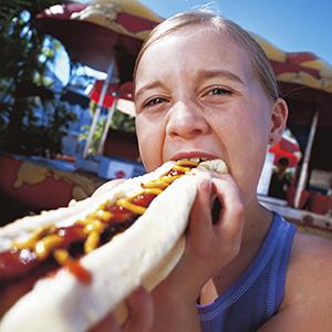 Girl eating a hotdog © Chris Williams Black Box/Getty Images