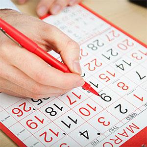 Office worker marking calendar with red pen © Image Source, Image Source, Getty Images