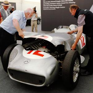 Bonhams employees replace the cover of the Mercedes-Benz W196 einsitzer ahead of its auction by Bonhams at the Goodwood Festival of Speed at Goodwood near Chichester in southern England © Luke MacGregor/Reuters