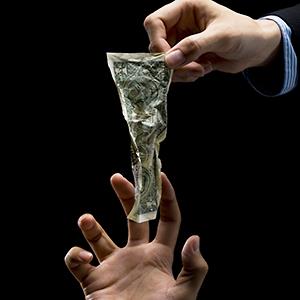 A hand delivering money © kokouu/Getty Images