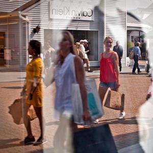 Image: File photo of shoppers reflected in a window at the Premium Outlets at Woodbury Common in Central Valley, New York (© Emile Wamsteker/Bloomberg via Getty Images)