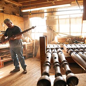 Credit: © John McDonnell/The Washington Post via Getty Images
Caption: A craftsman prepares wooden bed posts in a furniture factory.