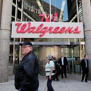 People walk by a Walgreens in Boston, Mass., on April 30, 2013 (Photo by Wendy Maeda/The Boston Globe via Getty Images)