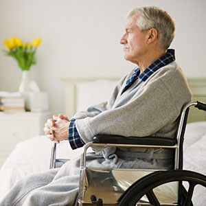 Image: Senior man in wheelchair looking out window (© Tetra Images/Getty Images)