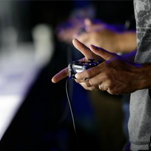 Show attendees play video games on the PlayStation 4 at the Sony booth during the Electronic Entertainment Expo in Los Angeles. © AP Photo/Jae C. Hong