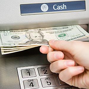 Person withdrawing cash © Image Source/Image Source/Getty Images