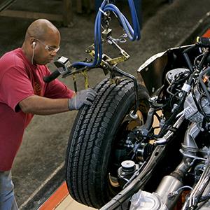 File photo of a Ford Motor Co. employee attaching a wheel to a 2009 Ford F-150 pickup truck on an assembly line at the company's Dearborn Truck Plant in Michigan on Oct. 30, 2008 (© Jeff Kowalsky/Bloomberg via Getty Images)